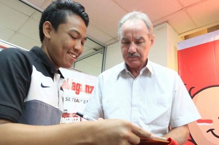 Pelatih timnas Indonesia, Alfred Riedl (kanan), saat melayani permintaan tanda tangan dari salah sat