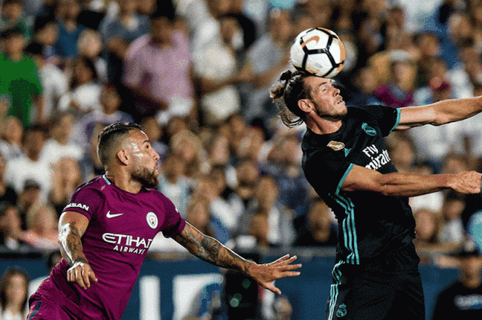 Penyerang Real Madrid, Gareth Bale (kanan), membuang bola dengan sundulan sagar tidak bisa dijangkau bek Manchester City, Danilo, saat kedua tim berlaga di ajang International Champions Cup di Stadion Los Angeles Memorial Coliseum, Los Angeles, California, AS, pada 26 Juli 2017.