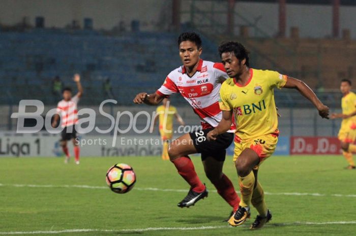 Pemain sayap Bhayangkara FC, Ilham Udin Armayn, dibayang-bayangi bek Madura United, Fachrudin Aryanto, pada pertandingan Liga 1, Rabu (8/11/2017). 