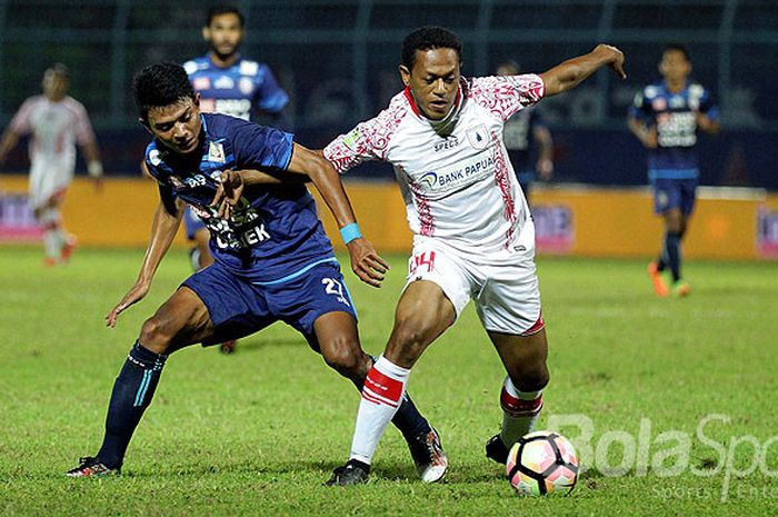 Gelandang Persipura Jayapura, Yohanis Tjoe (kanan), berebut bola dengan striker Arema FC, Dedik Setiawan, dalam laga pekan ke-15 Liga 1 di Stadion Kanjuruhan Kabupaten Malang, Jawa Timur, Minggu (16/07/2017) malam.