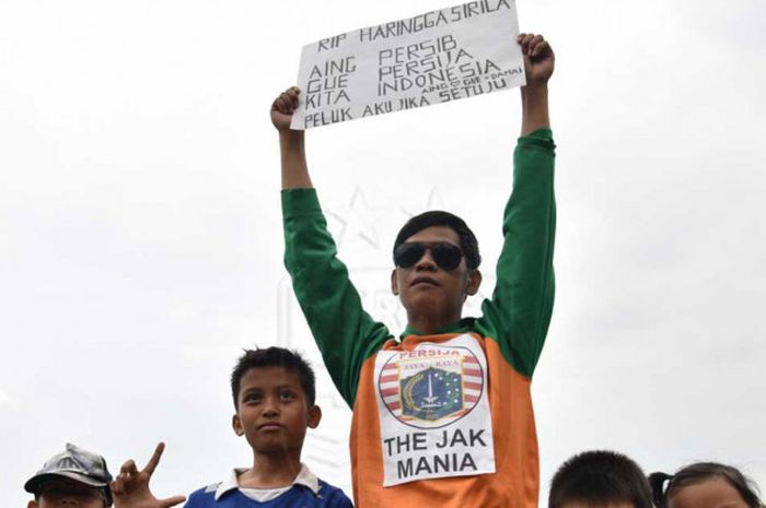 Eko Permadi, bobotoh asal Kacapiring, Kota Bandung, membawa papan pesan perdamaian antar suporter. 