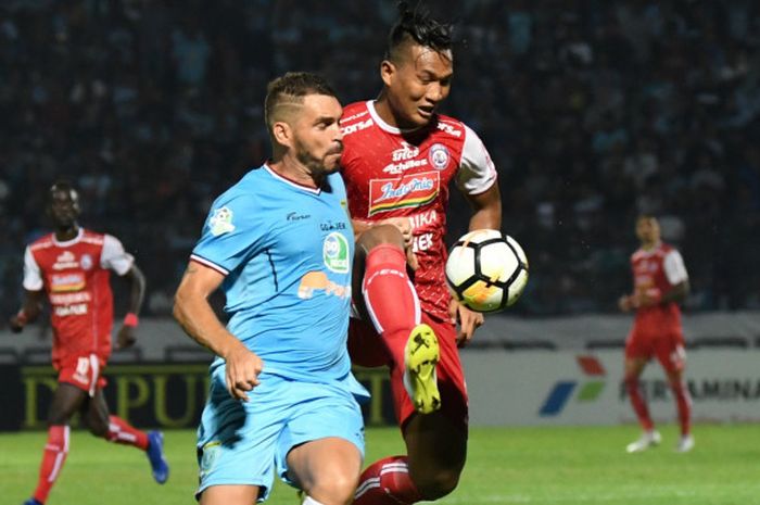 Striker Arema FC, Ahmad Nur Hardianto berebut bola dengan bek Persela Lamongan, Wallace Costa di Sta