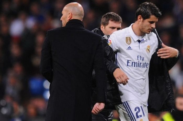 Penyerang Real Madrid, Alvaro Morata (kanan), saat ditarik keluar oleh pelatih Zinedine Zidane dalam duel La Liga kontra Real Betis di Stadion Santiago Bernabeu, Madrid, 12 Maret 2017.