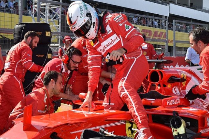 Pebalap Scuderia Ferrari, Sebastian Vettel, keluar dari kokpit mobilnya sebelum menjalani start balapan GP Jepang di Sirkuit Suzuka, 8 Oktober 2017.