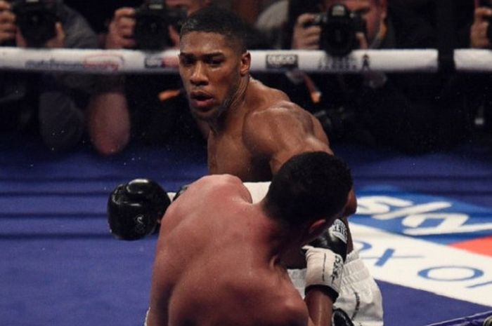 Petinju kelas berat Inggris, Anthony Joshua, melepaskan pukulan ke arah Joseph Parker (Selandia Baru) pada laga di Principality Stadium, Cardiff, Wales, Sabtu (31/3/2018).