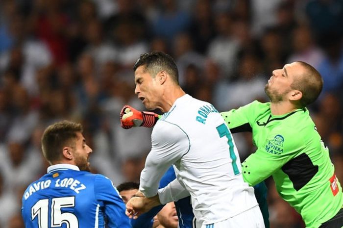 Megabintang Real Madrid, Cristiano Ronaldo (tengah), berduel dengan pemain Espanyol, David Lopez (kiri) dan Pau Lopez, dalam laga Liga Spanyol di Stadion Santiago Bernabeu, Madrid, pada 1 Oktober 2017.