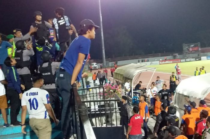 Polisi mengamankan suporter yang melempar botol ke dalam lapangan di pertandingan PSIS Semarang Vs PSM Makassar pada Senin (30/7/2018).