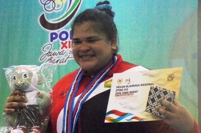 Lifter putri provinsi Aceh, Nurul Akmal, berpose dengan medali emas yang didapat dari cabang olahrag