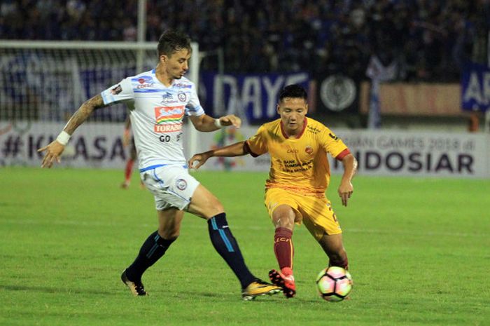 Pemain Sriwijaya FC, Syahrian Abimanyu saat mencoba melewati gelandang Arema FC, Rodrigo Ost dos Santos (kiri), di Stadion Manahan, Solo, Minggu (4/2/2018)