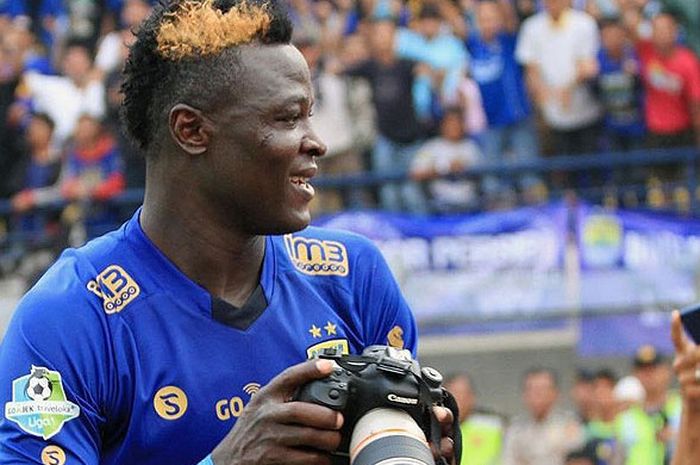 Striker Persib Bandung, Ezechiel N'Douassel, melakukan selebrasi dengan mengambil kamera seorang fotografer seusai mencetak gol ke gawang Semen Padang dalam laga pekan ke-23 Liga 1 di Stadion Si Jalak Harupat, Bandung, Sabtu (9/9/2017).