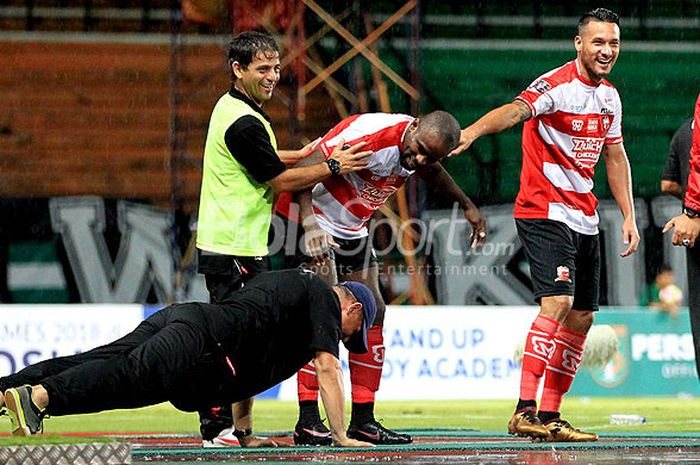 Pelatih Madura United, Gomes de Oliveira, melakukan push-up disaksikan Greg Nwokolo usai sang striker membobol gawang Perseru Serui pada hari pertama laga kedua Piala Presiden 2018 Grup C di Stadion Gelora Bung Tomo Surabaya, Jawa Timur, Kamis (18/01/2018) malam.