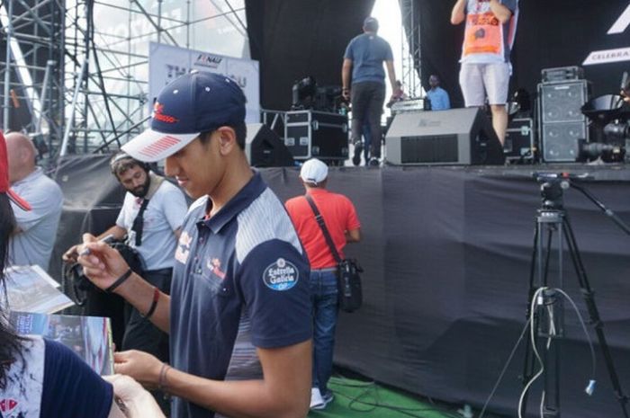 Pebalap Indonesia, Sean Gelael, memberikan tanda tangan dalam acara jumpa penggemar menjelang sesi Kualifikasi GP Malaysia di Sirkuit Sepang, Sabtu (30/9/2017).