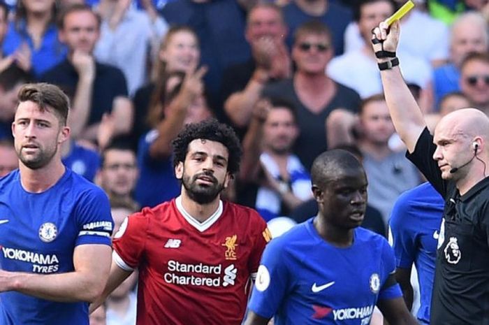 Wasit Anthony Taylor memberikan kartu kuning kepada Mohamed Salah (dua dari kiri) dalam partai Liga Inggris antara Chelsea kontra Liverpool di Stamford Bridge, London, 6 Mei 2018.