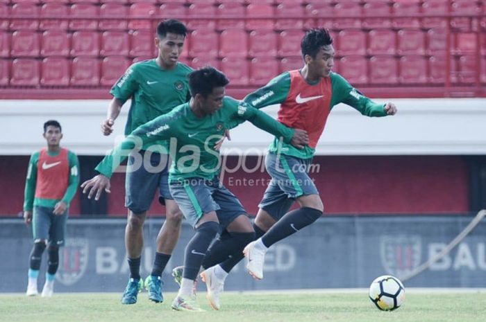 Septian David Maulana (kanan) berupaya meloloskan diri dari sergapan Bagas Adi Nugroho (tengah) dan Hanif Sjahbandi (kiri) dalam sesi latihan timnas U-23 Indonesia di Stadion Kapten I Wayan Dipta, Gianyar, Bali, Jumat (27/7/2018).