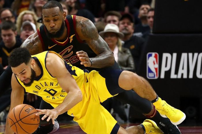 Pemain Indiana Pacers, Cory Joseph (jersey kuning, #6), berebut bola dengan pebasket megabintang Cleveland Cavaliers, LeBron James, pada laga gim kesatu babak pertama play-off Wilayah Timur NBA 2018 di Quicken Loans Arena, Cleveland, Ohio, Amerika Serikat, Minggu (15/4/2018). Pacers menang 98-80 dan untuk sementara unggul 1-0 atas Cavaliers.