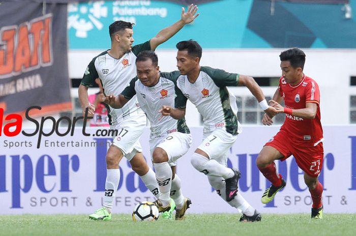  Pemain Persija, Fitra Ridwan mencoba merebut bola dari tiga pilar PS Tira, Dzimitry Rekish, Wawan Febriyanto, dan Ahmad Nufiandani (dari kiri ke kanan) pada laga pekan ke-30 Liga 1 2018 di di Stadion Wibawa Mukti, Cikarang Timur, Kabupaten Bekasi, Sabtu (10/11/2018). 