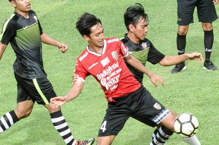 Penyerang Bali United, Hanis Saghara (merah) berusaha melindungi bola dari gangguan pemain Putra Tresna pada laga ujicoba, Jumat (12/1/2018) di Lapangan Banteng, Seminyak. Laga tersebut berakhir dengan skor 7-1 untuk Bali United 