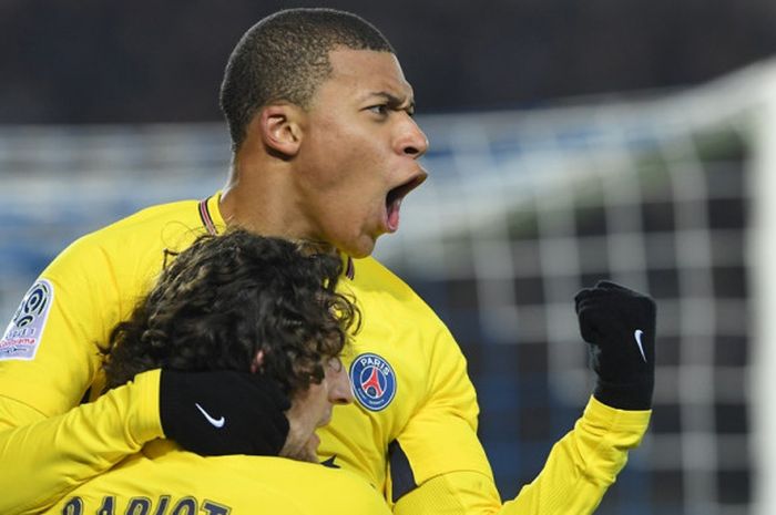 Striker Paris Saint-Germain, Kylian Mbappe (atas), merayakan gol yang dia cetak bersama Adrien Rabiot dalam laga Liga Prancis kontra Strasbourg di Stade de la Meinau, Strasbourg, pada 2 Desember 2017.