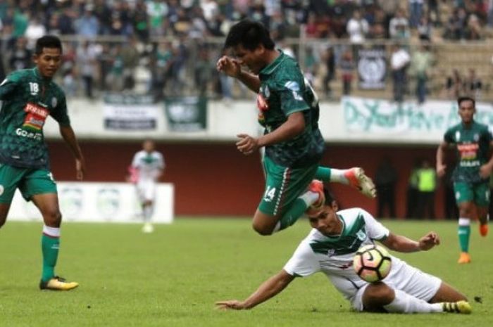 Pemain PSS Sleman (hijau) terjatuh seusai dijegal pemain PSMS Medan (putih) saat pertandingan uji coba di Stadion Maguwoharjo, Sleman, DI Yogyakarta, Minggu (4/3/2018). Dalam laga tersbeut PSS Sleman kalah dari PSMS Medan dengan skor 1-2 