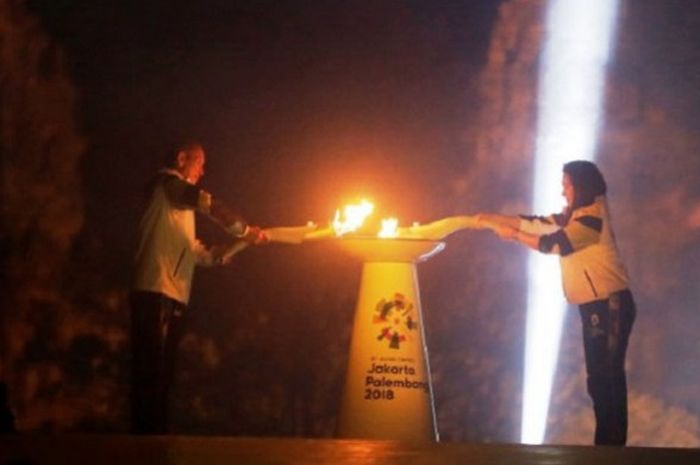 Atlet Legendaris Indonesia, Susy Susanti dan Yustedjo Tarik menyatukan api dari India dan api abadi Mrapen untuk obor Asian Games 2018 di kawasan Candi Prambana Yogyakarta, Rabu (18/7/2018). Obor Asian Games yang merupakan gabungan api dari India dan api abadai Mrapen akan dibawa berkeliling dio 54 kota di Indonesia sebelum untuk pembukaan Asian Games di Jakarta pada 18 Agustus mendatang. 