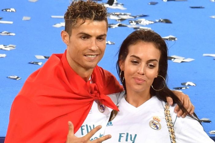     Bintang Real Madrid, Cristiano Ronaldo, berpose dengan kekasihnya, Georgina Rodriguez, saat merayakan kesuksesan tim menjuarai Liga Champions seusai menekuk Liverpool FC 3-1 dalam final di Stadion NSC Olimpiyskiy, Kiev, Ukraina, pada Sabtu (26/5/2018).    