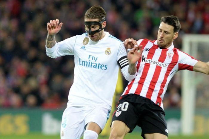 Bek Real Madrid, Sergio Ramos (kiri), berduel dengan striker Athletic Bilbao, Aritz Aduriz, dalam laga Liga Spanyol di Stadion San Mames, Bilbao, pada 2 Desember 2017.