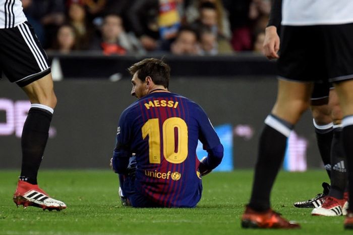 Megabintang FC Barcelona, Lionel Messi, duduk di lapangan dalam laga leg kedua semifinal Copa del Rey kontra Valencia di Stadion Mestalla, Valencia, Spanyol, pada 8 Februari 2018.