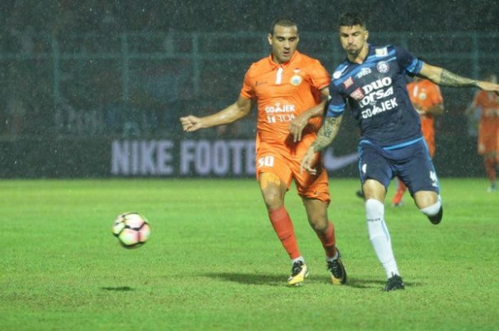 Adu lari penyerang Persija Jakarta, Bruno Lopes (kiri) dengan bek Arema FC, Arthur Cunha pada laga pekan ke-26 Liga 1 musim 2017 di Stadion Kanjuruhan, Kabupaten Malang pada Minggu (24/9/2017) malam. 