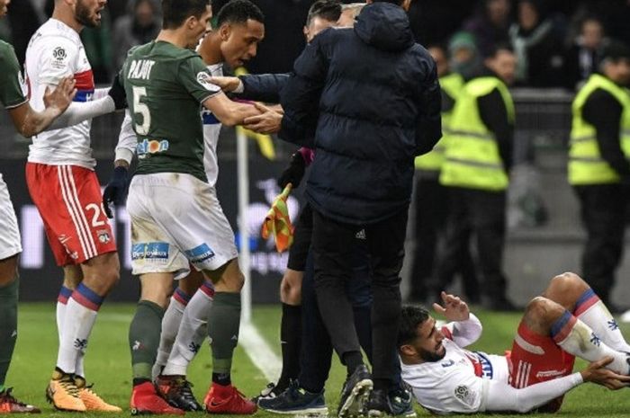 Pemain depan Lyon, Nabil Fekir, tampak kesakitan usai ditekel keras oleh pemain Saint-Etienne, Leo Lacroix.