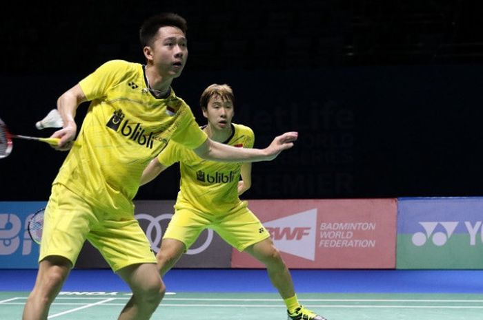 Pasangan ganda putra Indonesia, Marcus Fernaldi Gideon/Kevin Sanjaya Sukamuljo, mengembalikan kok ke arah Li Junhui/Liu Yuchen (China) pada laga akhir penyisihan Grup A BWF Superseries Finals 2017 yang berlangsung di Hamdan Sports Complex, Dubai, Jumat (15/12/2017).