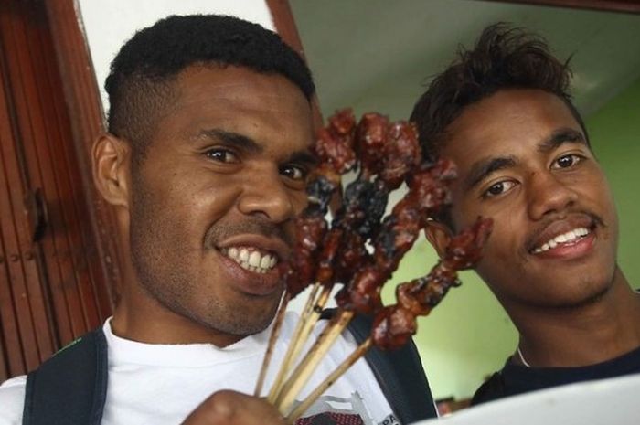 Pemain Semen Padang menikmati sate di pedagang kaki lima usai latihan