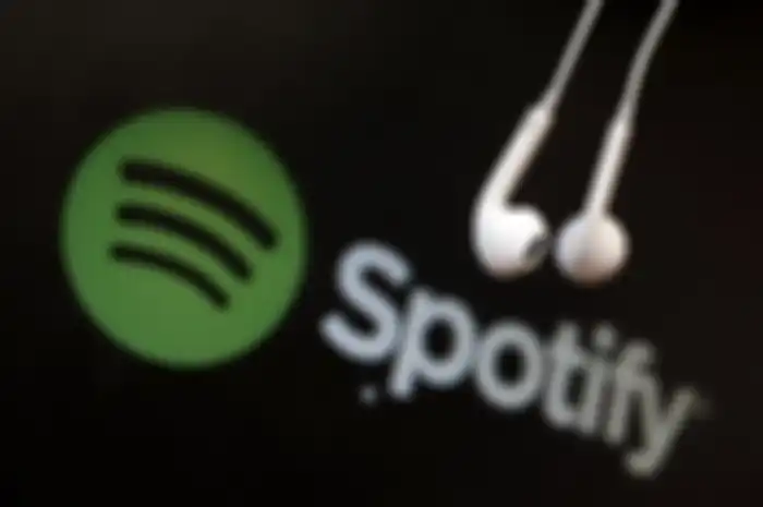 Headphones are seen in front of a logo of online music streaming service Spotify in this illustratio