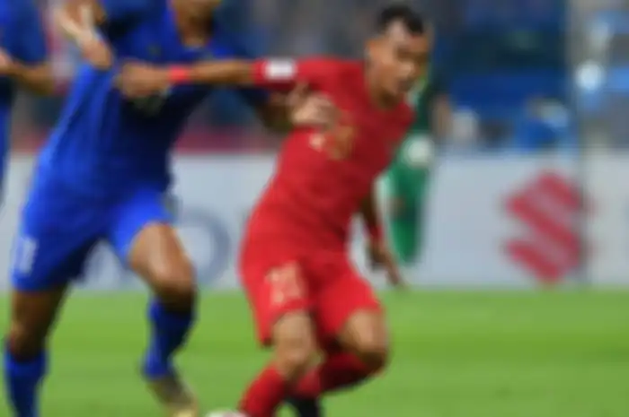 Riko Simanjutak berebut bola dengan pemain Thailand