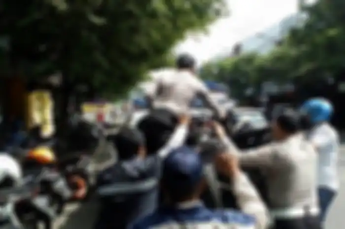 Petugas kepolisian dibantu warga saat mengangkut dua sepeda motor yang terlibat bentrok di Jalan Gatot Subroto, Kota Malang, Kamis (24/1/2019)&nbsp;