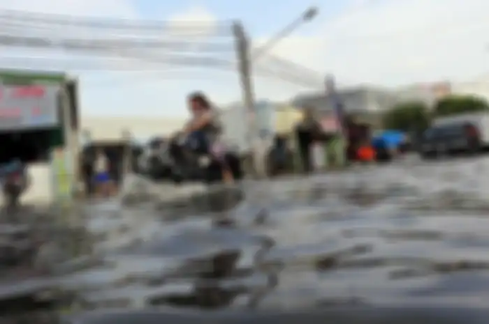 Pengendara melintasi banjir yang menggenangi Jalan Kramat Jaya, Semper Barat, Jakarta Utara, Rabu (12/3/2014). Setiap kali hujan lebat mengguyur kawasan itu, jalan tersebut selalu banjir. Hal itu diperparah oleh sistem drainase yang buruk. Warta Kota/angga bhagya nugraha