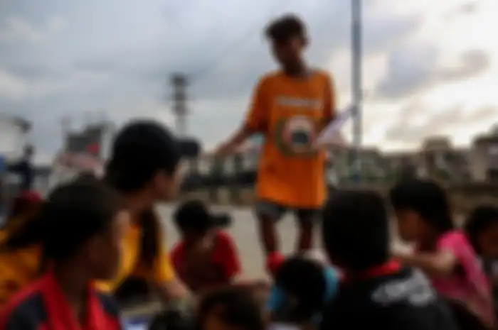 Sejumlah anak-anak saat belajar disebuah terpal yang disediakan oleh Relawan Mentari Senja di kawasan jalan inpeksi sungai banjir kanal barat, kawasan Tanah Abang, Jakarta, Kamis (7/2/2019). Relawan yang terdiri dari pemuda-pemudi yang masih sekolah dan kuliah ini melakukan kegiatan sosial dengan me