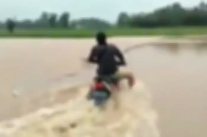 Pemotor Honda Supra X terobos banjir