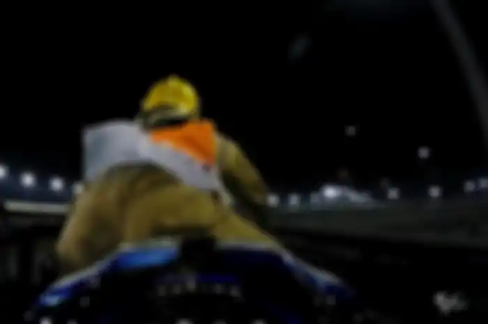 Aksi marshal menunggangi motor balap yang digendong di atas gerobak pengangkut menuju paddock