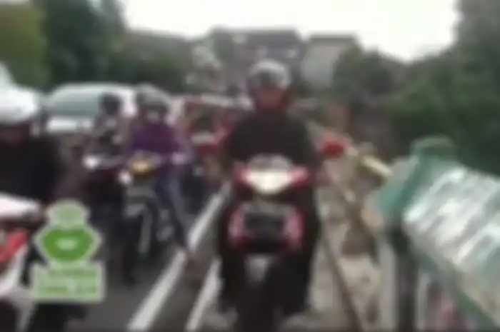 Seorang pria hadang para pelanggar peraturan dengan mengambil hak pejalan kaki di trotoar