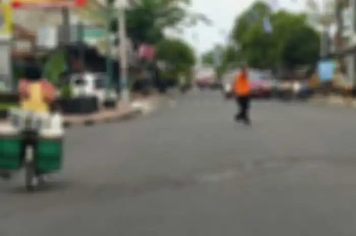 Seorang bapak bantu lalu lintas di Tamansari Jogjakarta