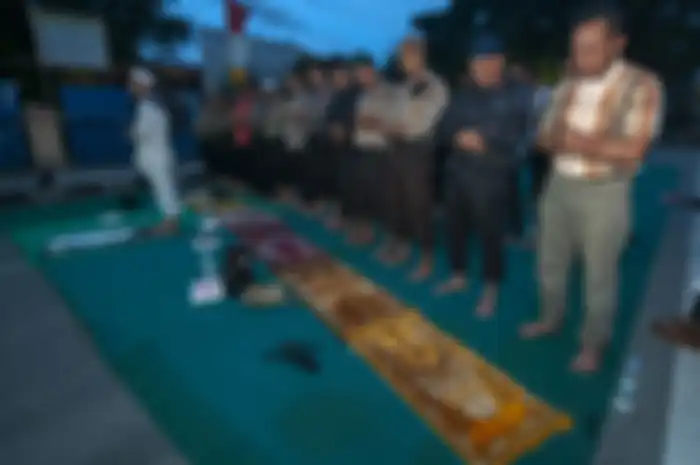 Sejumlah personel kepolisian menunaikan ibadah shalat maghrib usai berbuka puasa di tengah mengamankan aksi unjuk rasa di depan kantor Komisi Pemilihan Umum (KPU) Sulawesi tengah di Palu, Sulawesi Tengah, Rabu (22/5/2019).