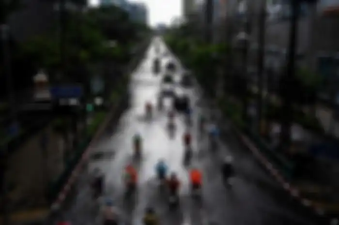  Para pengendara menembus jalan yang terendam banjir setelah hujan deras di Bangkok.