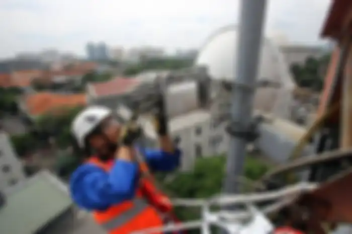 Teknisi XL Axiata melakukan perawatan BTS