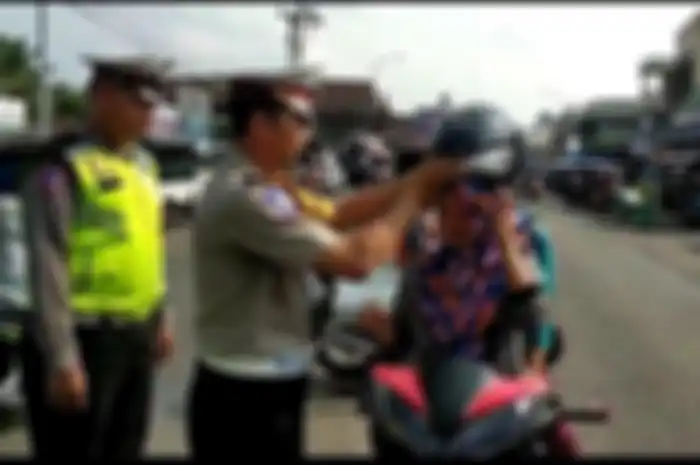 Kasatlantas Iptu M Lubis membagikan helm gratis ke pengendara sepeda motor, yang melintas didepan Mapolres Empatlawang, Rabu (26/6/2019)&nbsp; 