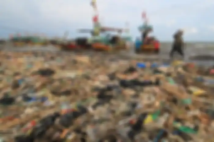 Nelayan menyandarkan perahunya di bibir pantai yang dipenuhi sampah plastik di Desa Dadap, Indramayu, Jawa Barat, Senin (26/11). ANTARA FOTO/Dedhez Anggara