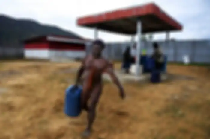 Warga membawa jerigen berisi BBM usai membeli di SPBU Kompak, Kampung Obano, Distrik Paniai Barat, Papua, Kamis (29/11/2018). Meski dengan upaya distribusi yang tidak mudah, program BBM satu harga menjadi sangat vital bagi masyarakat pedalaman Papua guna mendukung berbagai aktivitas mereka.