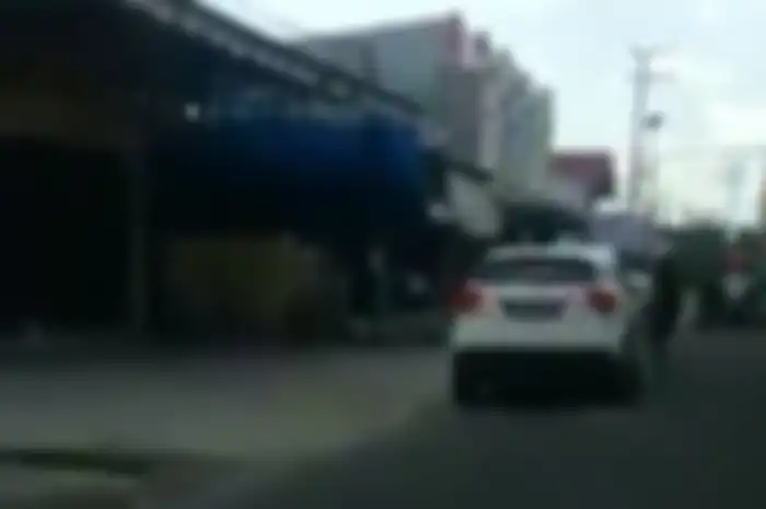 Pemotor ngamuk hantam kaca mobil pakai helm.