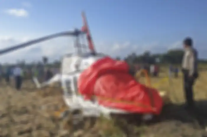 Polisi berjaga di dekat pesawat helikopter B206L4 PKCDV milik PT Carpediem Air rute Labuan Bajo-Lombok yang jatuh di luar pagar Bandara Internasional Lombok di Desa Kawo, Kecamatan Pujut, Praya, Lombok Tengah, NTB, Minggu (14/7/2019). Tiga WNA penumpang helikopter, Luka Marie (Jerman), Nicholas Ale