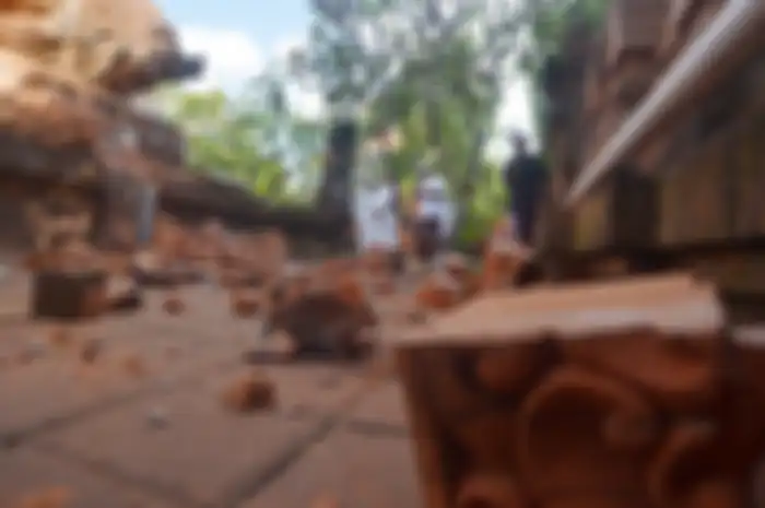 Pemuka agama Hindu memantau kerusakan pada bagian candi yang runtuh akibat gempa di Pura Lokanatha, Denpasar, Bali, Selasa (16/7/2019). Gempa yang mengguncang Bali pada magnitudo 6 (selanjutnya dilakukan pemutakhiran menjadi magnitudo 5,8) pukul 08.18 Wita tersebut tidak menimbulkan korban jiwa, tap