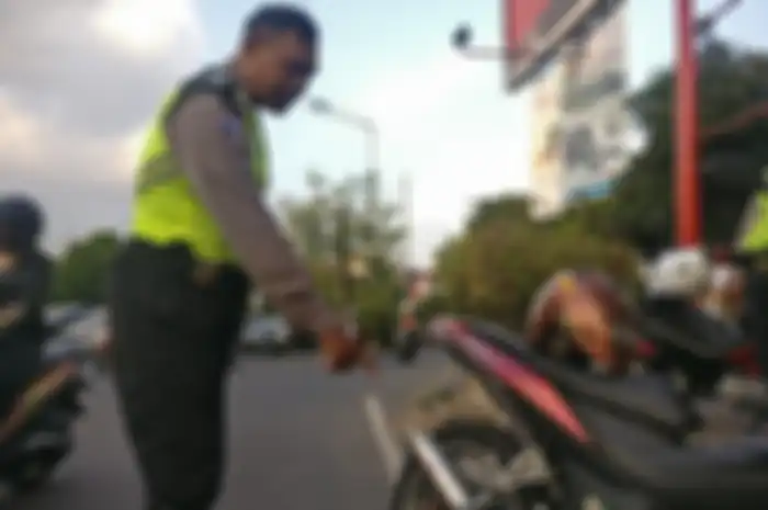 Ilustrasi polisi menunjukan pelanggaran berupa pemakaian knalpot tidak sesuai standar